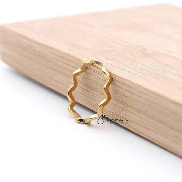 Glitters 18K gold plated stainless steel wavy women's ring showcasing a sleek, shiny design on a polished ring.