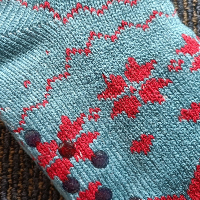 Pair of women’s fuzzy winter slippers with soft fabric and non-slip grippers, ideal for warmth and comfort.
