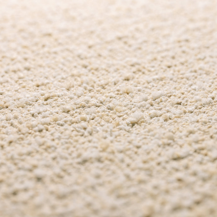 A close-up texture shot of a light beige, granular material such as sand, gravel, or fine sandpaper.
