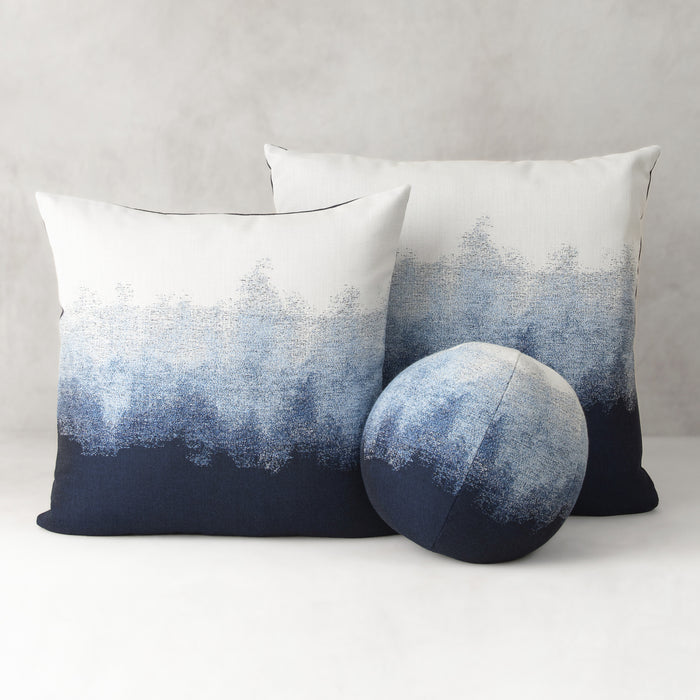 Two pillows with a gradient design from blue to white on a gray background