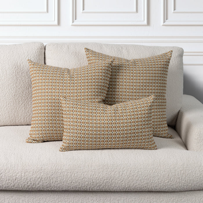 Indoor & Outdoor safe pillows in brown, camel and gold geometric pattern on ivory boucle sofa