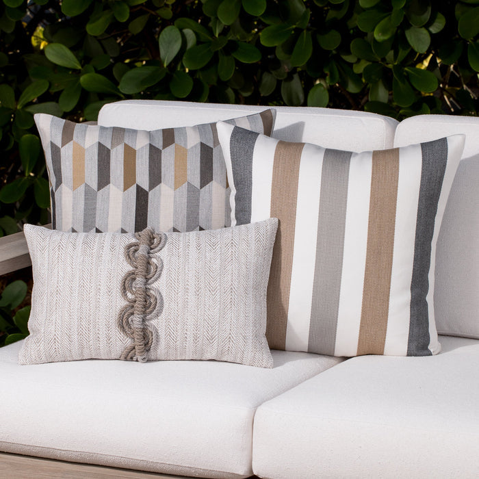Luxury neutral embroidered accent cushion on a woven lounge chair, featuring rich texture for layered decor for indoor and outdoor use