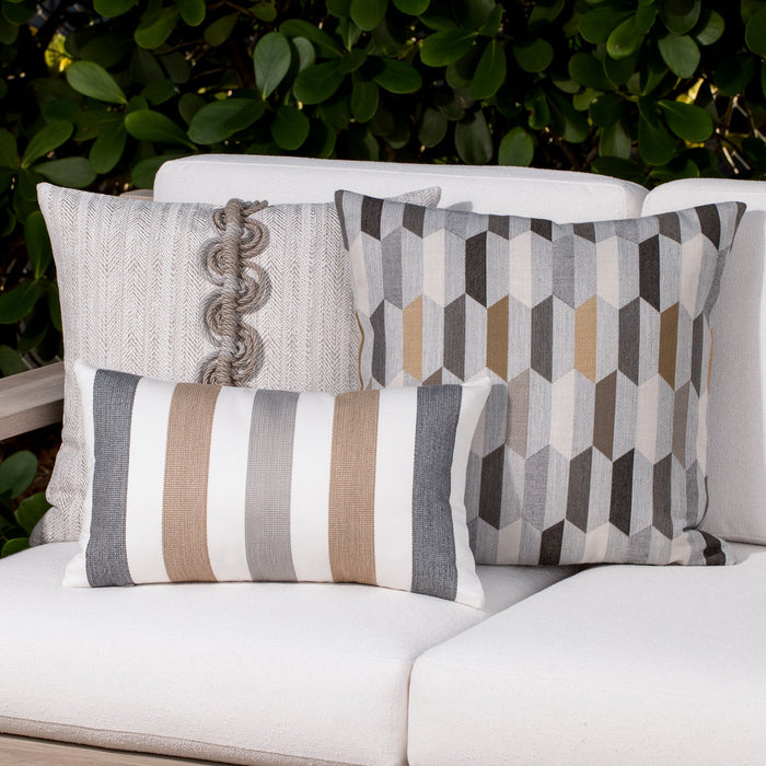 Luxury neutral embroidered accent cushion on a woven lounge chair, featuring rich texture for layered decor for indoor and outdoor use