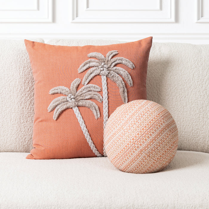 Decorative pillow with palm tree design on a couch