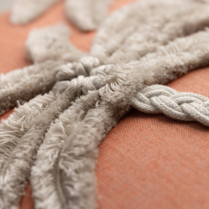 Close-up of a textured flax details on a coral-colored fabric