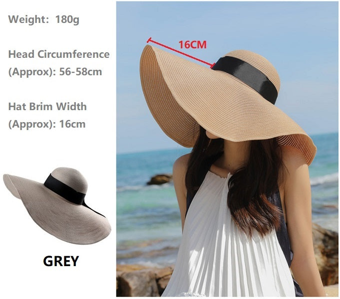 Grey women's straw sun hat with a wide brim, floppy derby style, perfect for summer beach or outdoor wear.