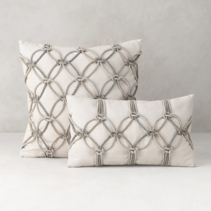 Two decorative pillows with geometric patterns on a neutral background