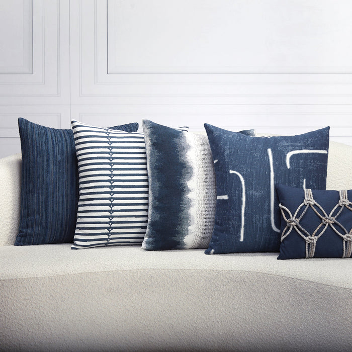 Indoor environmental image of pillows in Sophisticated stripe in deep denim on ivory boucle ground outdoor safe woven fabric