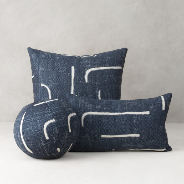 Two blue pillows with white abstract patterns on a gray background