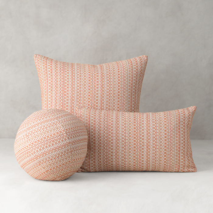 Three woven pillows in a pattern on a plain background