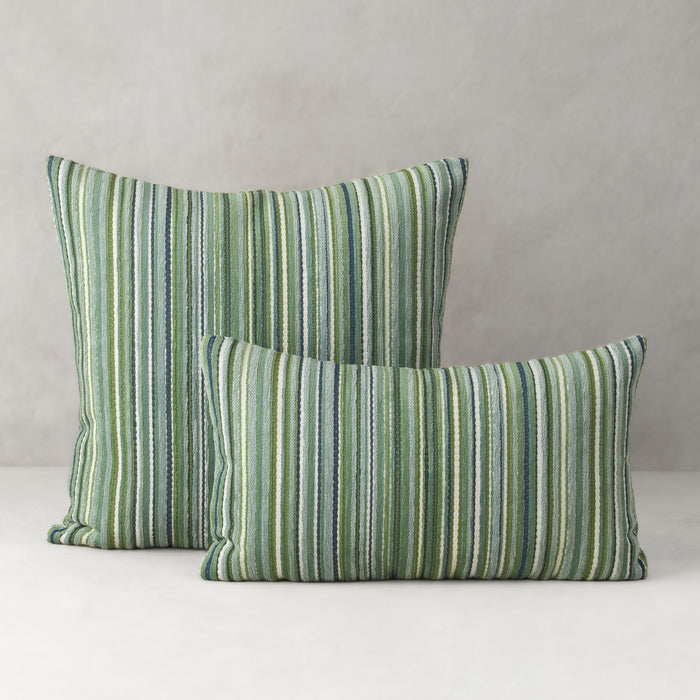 Two green striped pillows on a neutral background