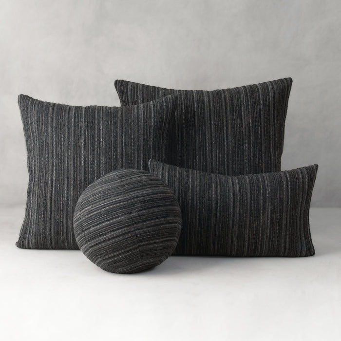 Set of black striped cushions on a white surface with a gray background