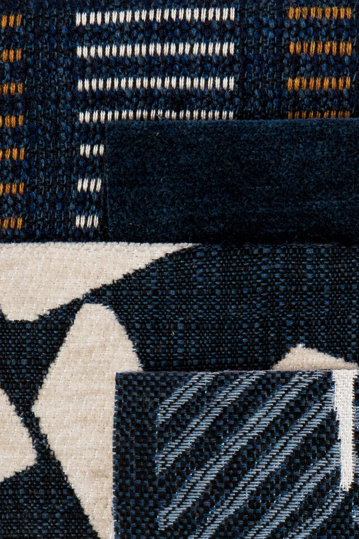 Coordinating fabrics to Decorative pillows on a white outdoor sofa with green foliage in the background