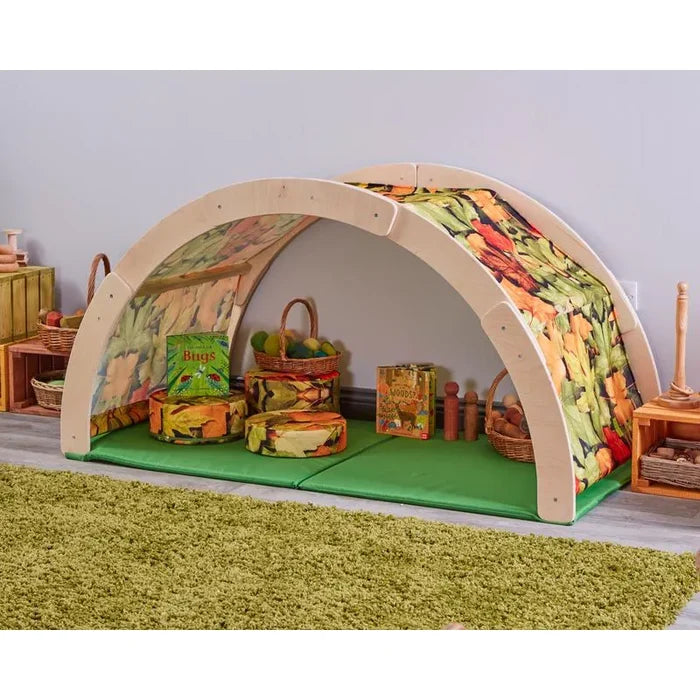 Children's playhouse with vegetable-themed fabric on a green rug