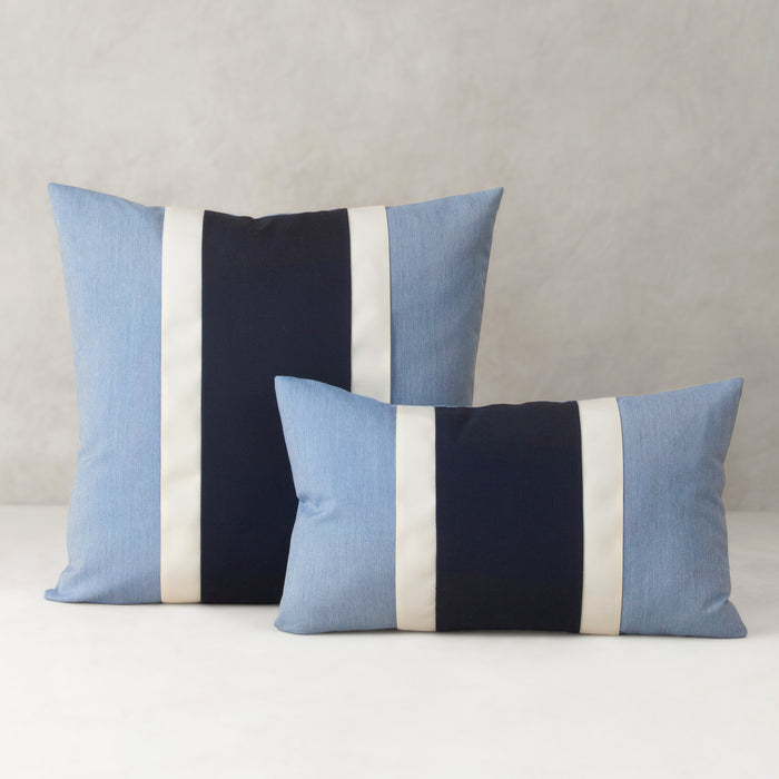 Two striped pillows with blue, black, and white colors on a neutral background