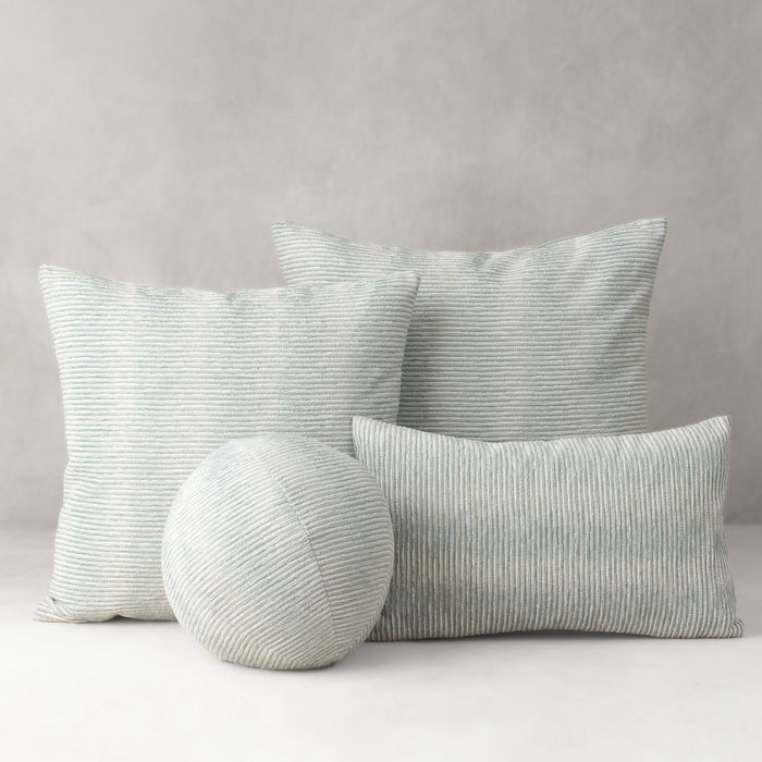 Set of striped cushions and a round pillow on a neutral background