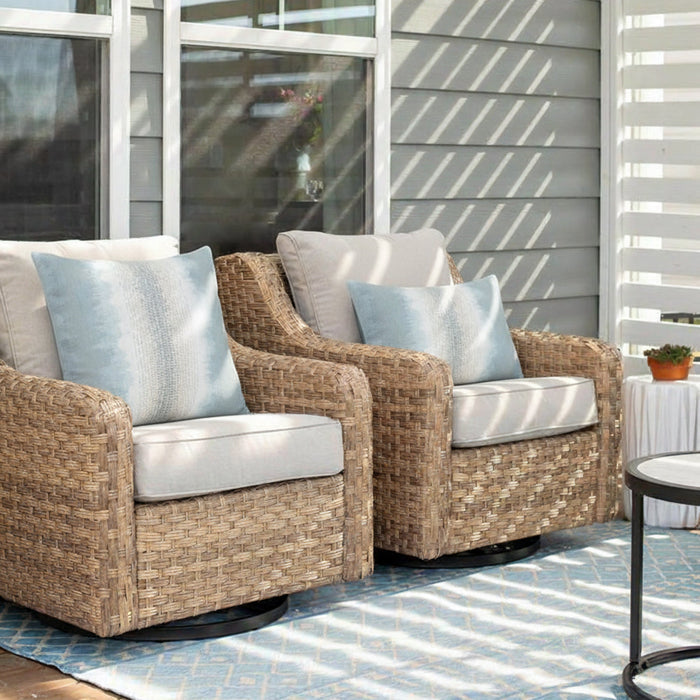 Outdoor safe ombre striped pillows in light blue and white on modern wicker outdoor chairs