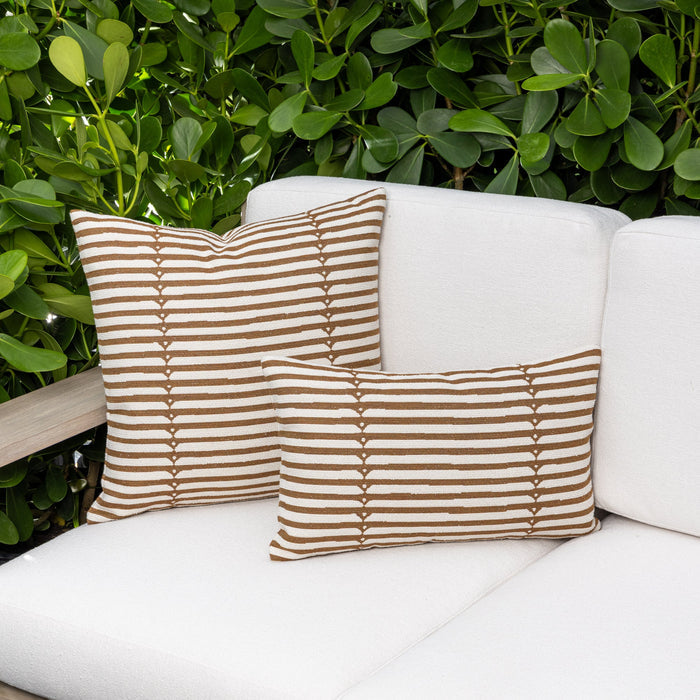 Outdoor image of pillows in Sophisticated stripe in caramel on ivory boucle ground outdoor safe woven fabric
