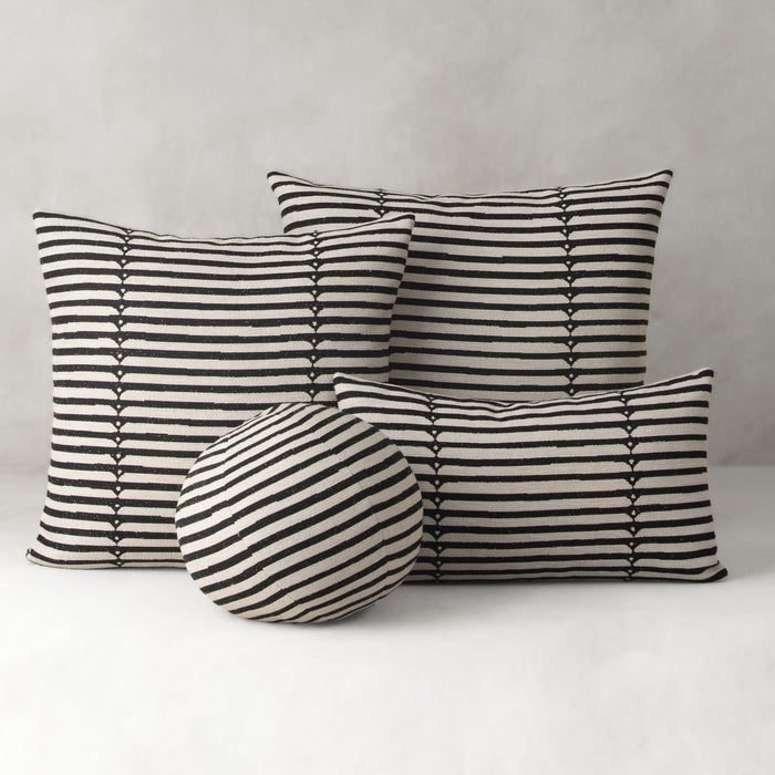 Set of black and white striped cushions on a neutral background