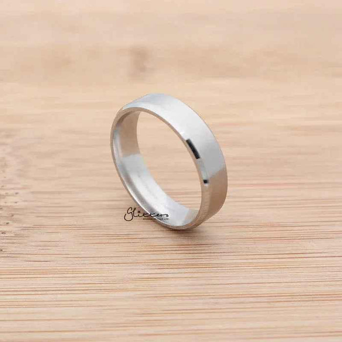Silver stainless steel 6mm wide beveled edge band ring from Glitters, showcasing a sleek, polished design and smooth beveled edges.