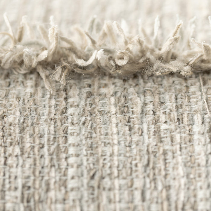 Close-up of textured beige fabric with frayed edge