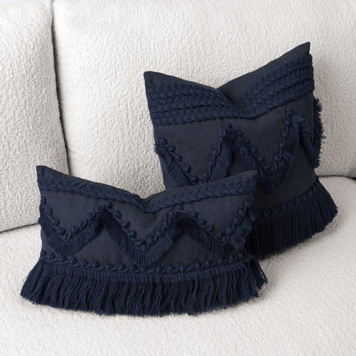 Two navy blue or indigo decorative pillows by Elaine Smith with fringe on a white sofa