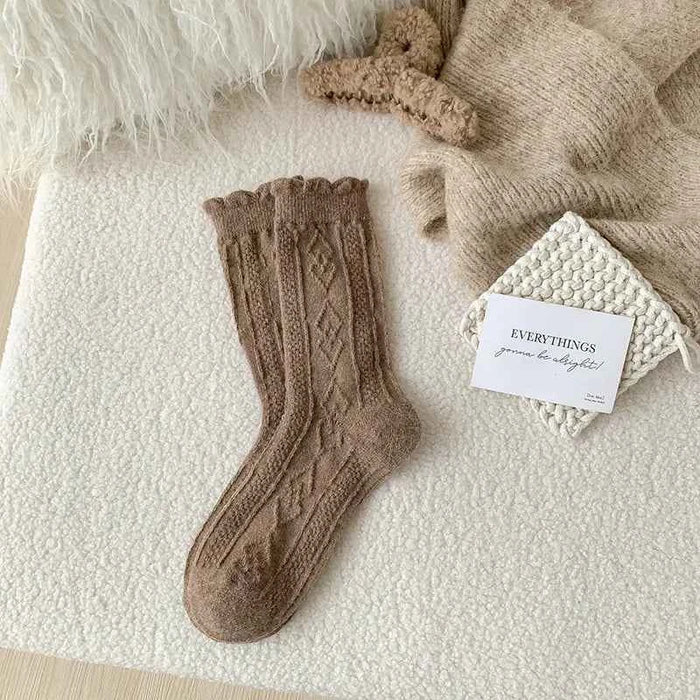 Thick diamond-shaped wool mid-thigh socks for women, cozy winter leg warmers in light rice color by Mead's Supply & Equipment.