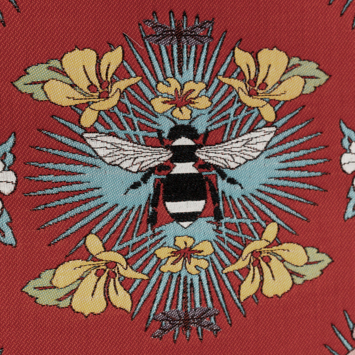 Detail image of Red outdoor safe fabric with tropical bee and floral motif featuring textured yarns and chenille accents