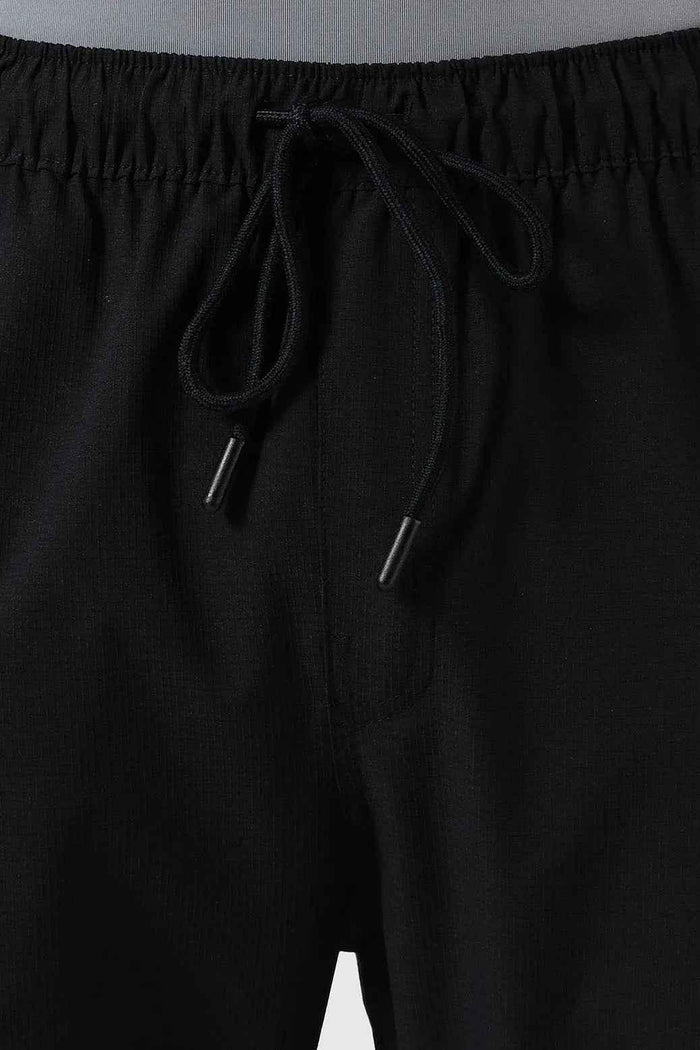 Fuaark Nz Vitality Straight Black Track Pants laid flat, showing their sleek design and comfortable fit for active wear.