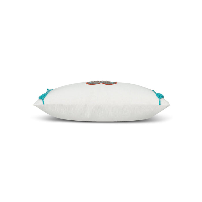 Side image of White pillow with cut out heart in red and gray and aruba tassels in western theme.